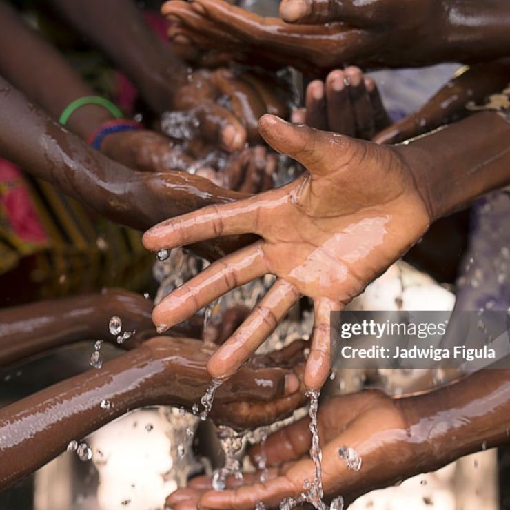 Stream of water pouring into children’s hands in southern Burkina Faso.