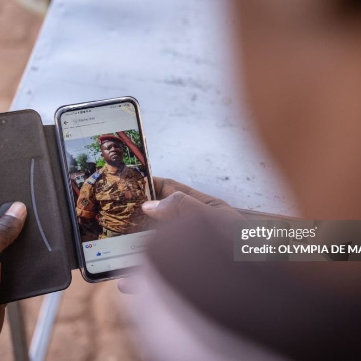 A man looks on his smartphone at the picture of Paul-Henri Sandaogo Damiba the leader of the mutiny and of the Patriotic Movement for the Protection and the Restauration (MPSR) in Ouagadougou on January 25, 2022. - In the aftermath of the coup d'etat in Burkina Faso which overthrew President Roch Marc Christian Kaboré, a demonstration in support of the putschists is scheduled for Tuesday in Ouagadougou where calm has returned after days of tension. (Photo by OLYMPIA DE MAISMONT / AFP) (Photo by OLYMPIA DE MAISMONT/AFP via Getty Images)