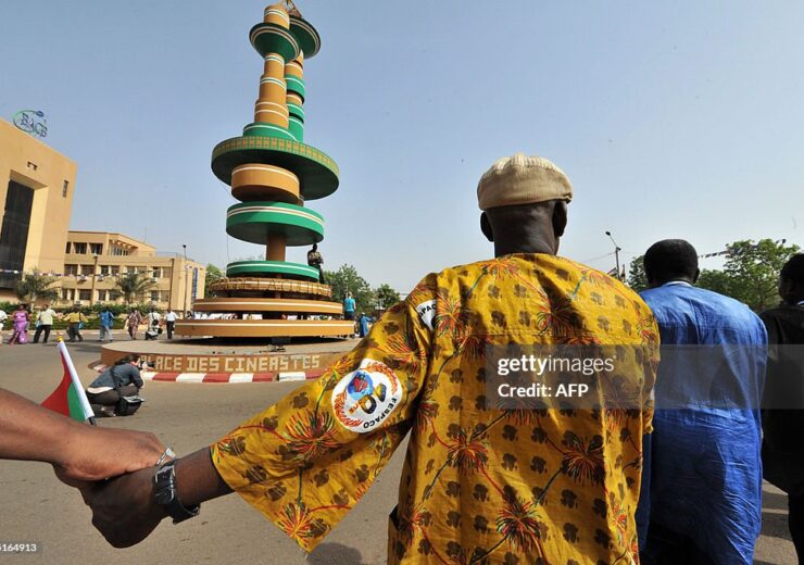 African film directors and cinema business representatives hold hands and circle a monument dedicated to the cinema in Ouagadougou on March 1, 2009 during the 21st edition of Fespaco (Panafrican festival of cinema and television). 19 movies from 13 African countries are in competition during the festival ending on March 7.  AFP PHOTO GEORGES GOBET (Photo credit should read GEORGES GOBET/AFP via Getty Images)